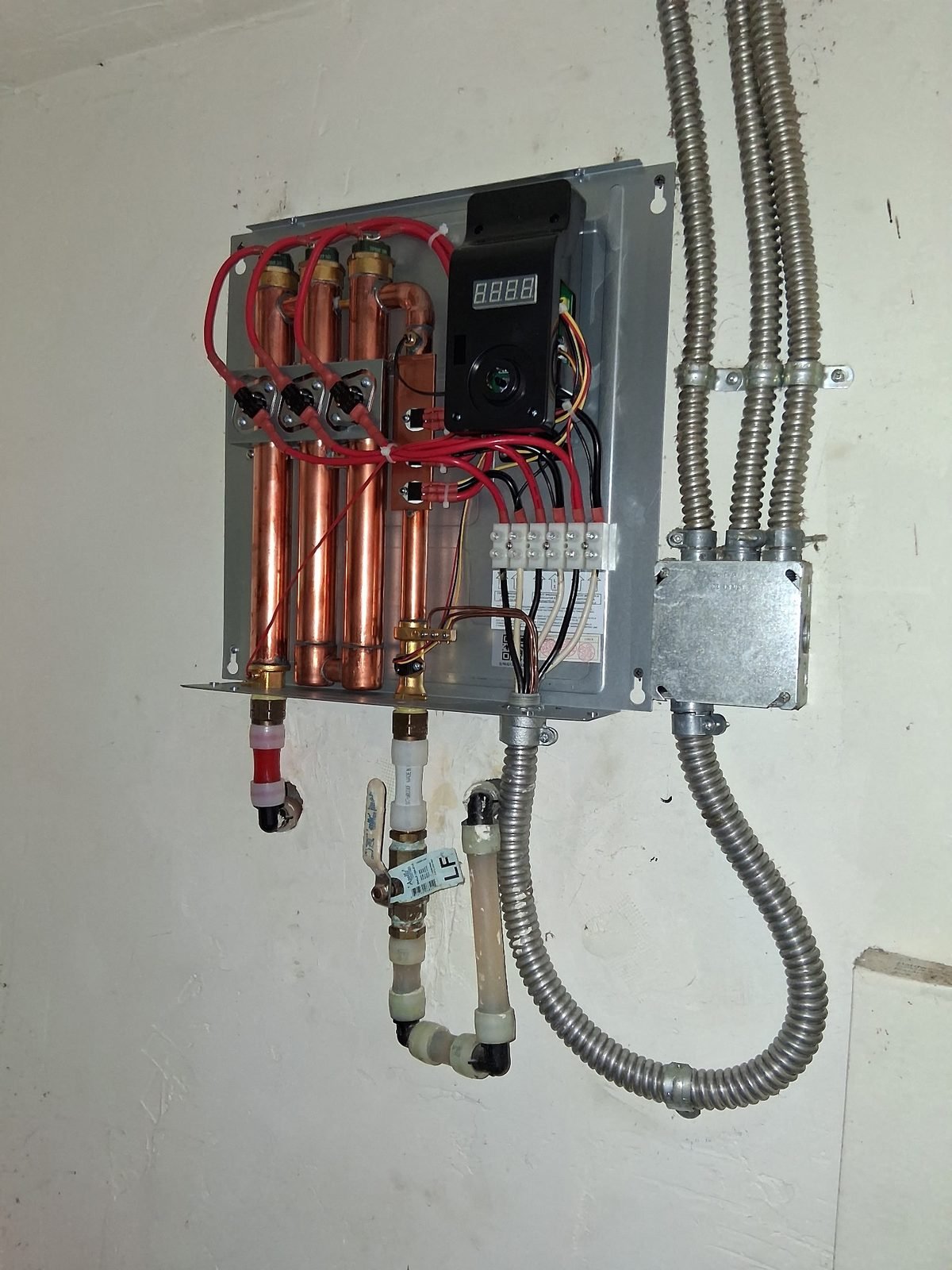 Tankless water heater internal components — heating element and copper piping installation by Trade Pro Services